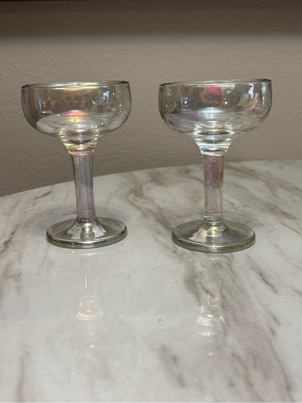 Iridescent glass champagne coupes with a short stem and a rainbow pearl finish